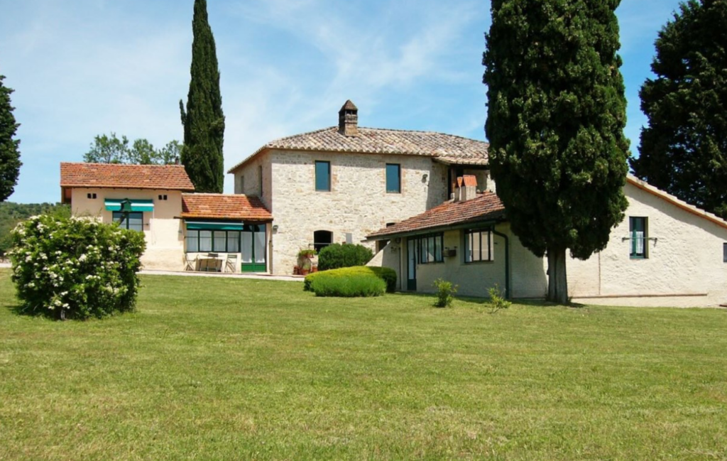 Stone house with lawn and cypresses