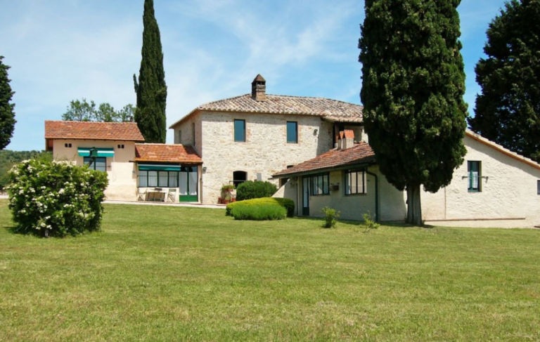 Stone house with lawn and cypresses