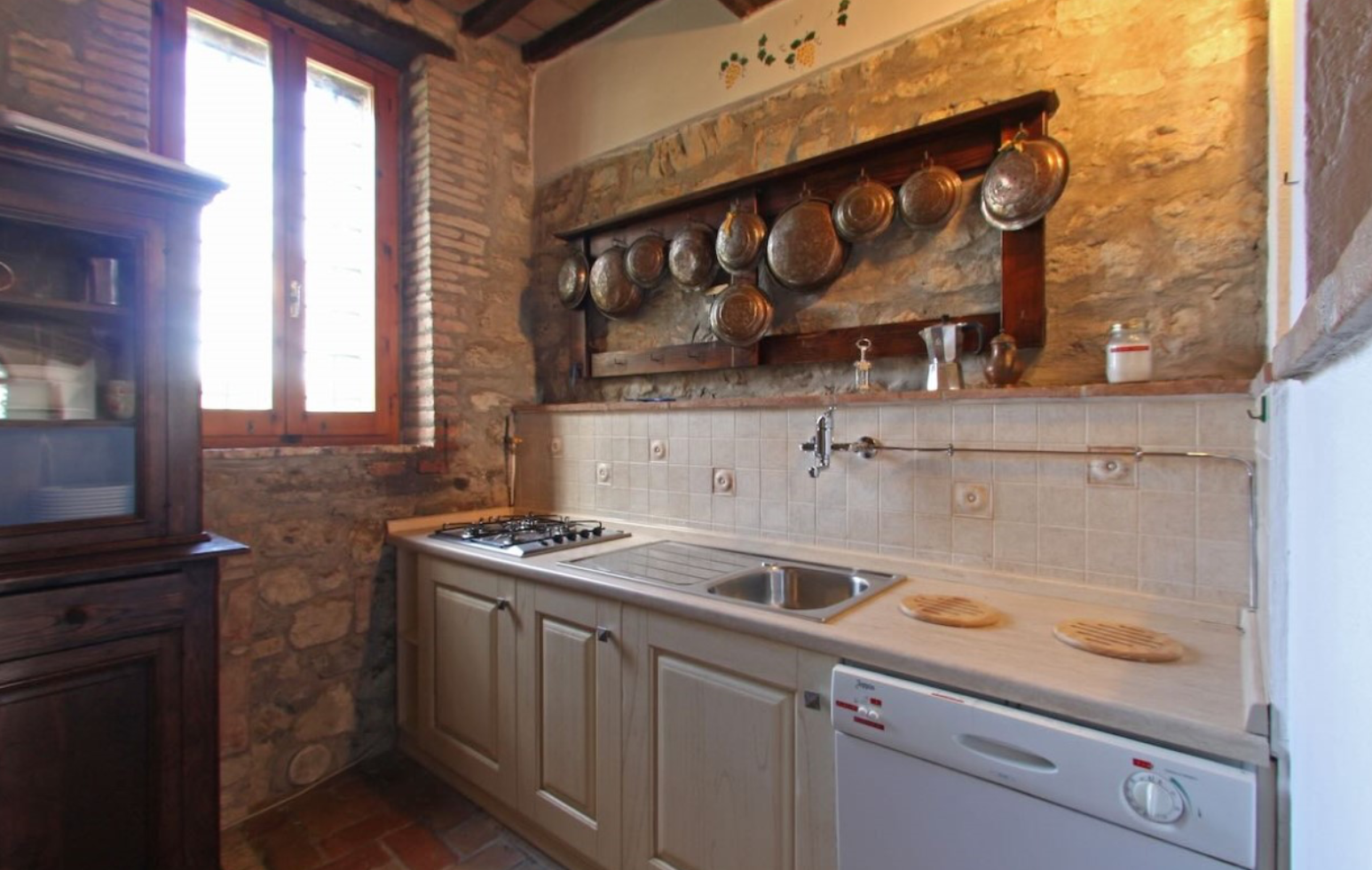 Stay Kitchen with stone wall and copper pans