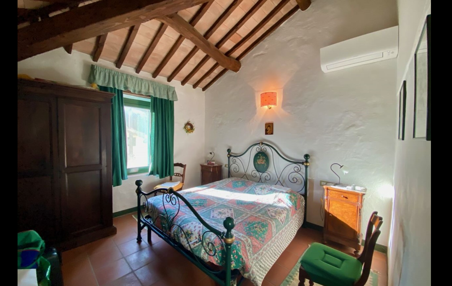 Stay Bedroom with wrought-iron bed and beamed ceiling