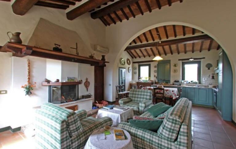 Living room with stone arch, seating area and fireplace in the Gran Marco apartment