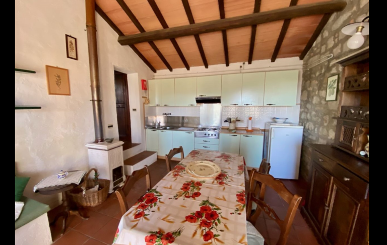 Kitchen with dining table under a beamed ceiling in the Gaia apartment