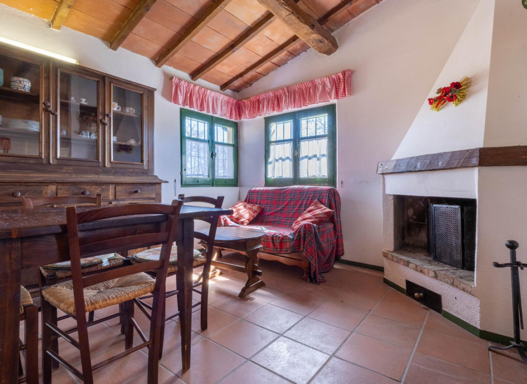 Living room with fireplace and dining table in Cottage Fragolina Di Bosco