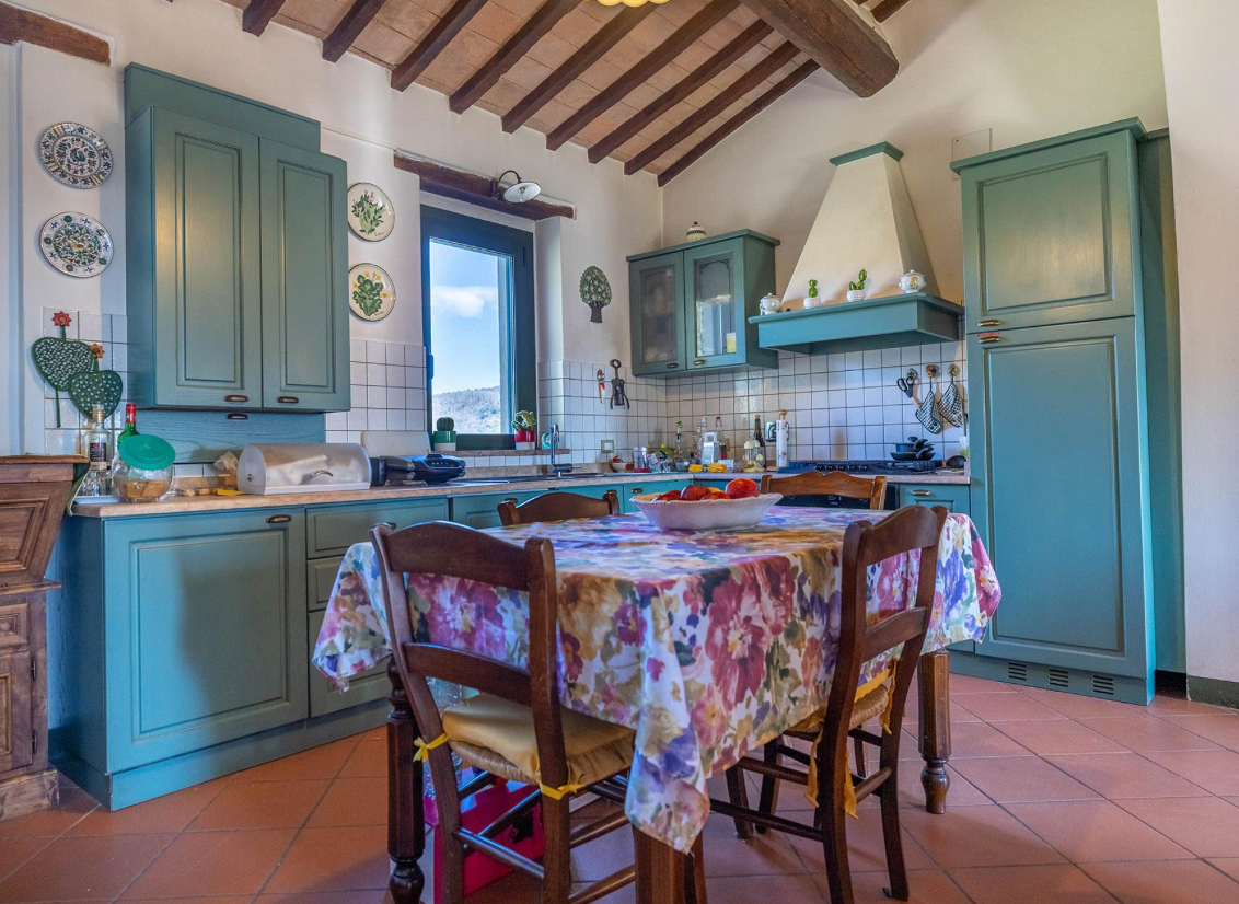 Stay Kitchen with green cupboards and dining table