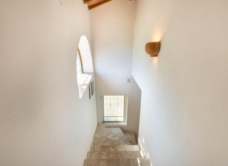 Bright stairwell with round window in the Ribes apartment