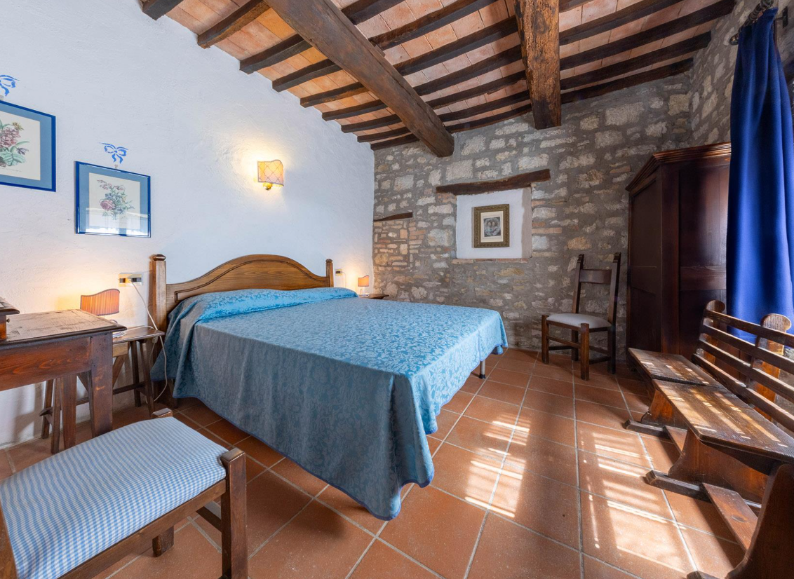 Stay Bedroom with stone wall and wooden furniture