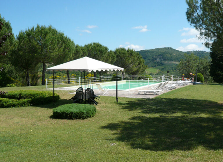 Swimming pool at Casa Tre Pettirossi with a party tent and sun loungers in the garden