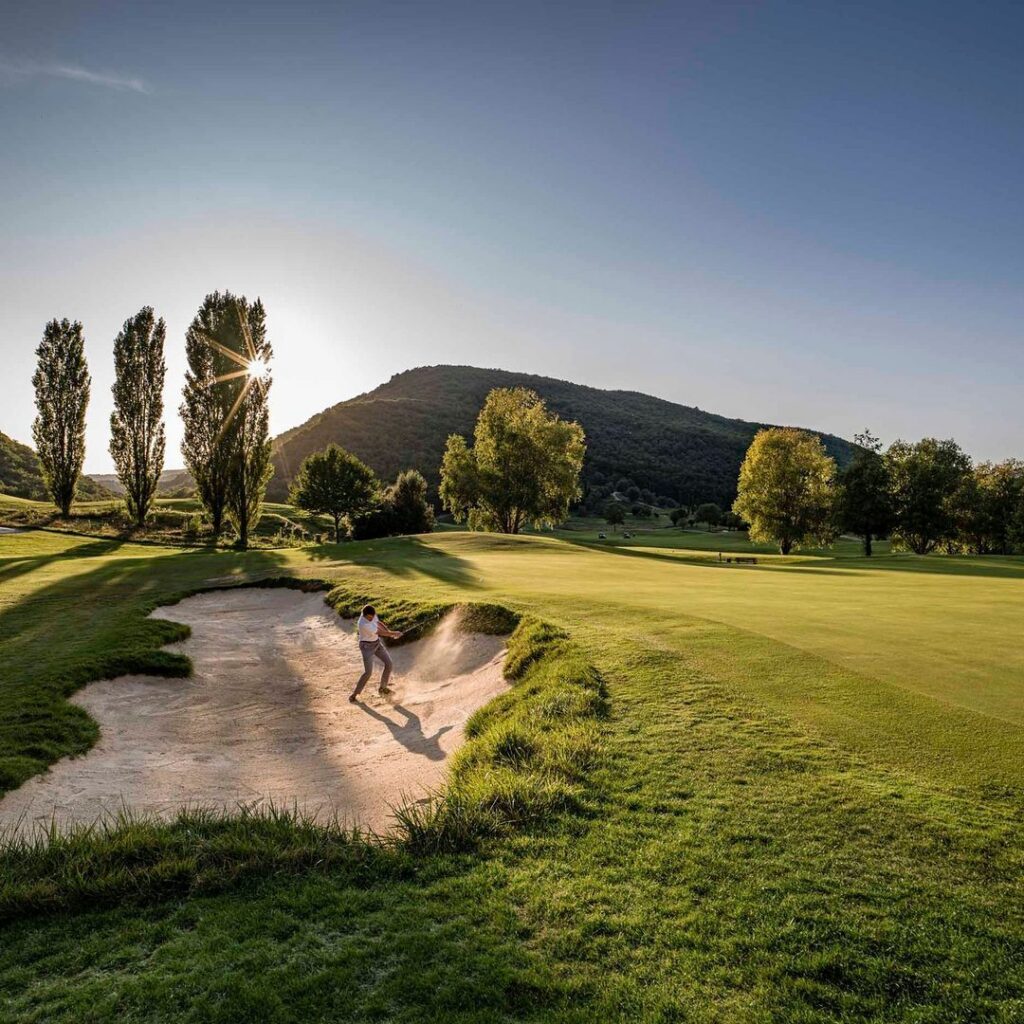 Bunker en fairway van Antognolla Golf tussen de bomen