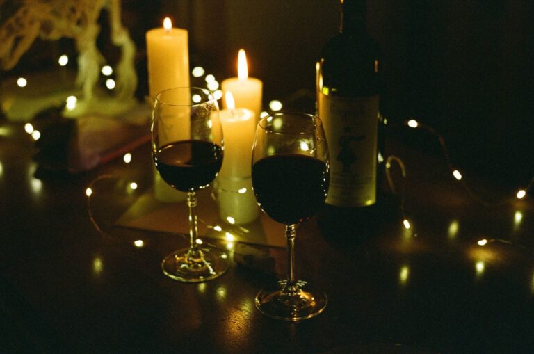 Wine glasses and a bottle of wine by candlelight