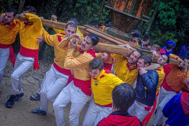 Ceraioli running in yellow with their cero during the Festa dei Ceri in Gubbio