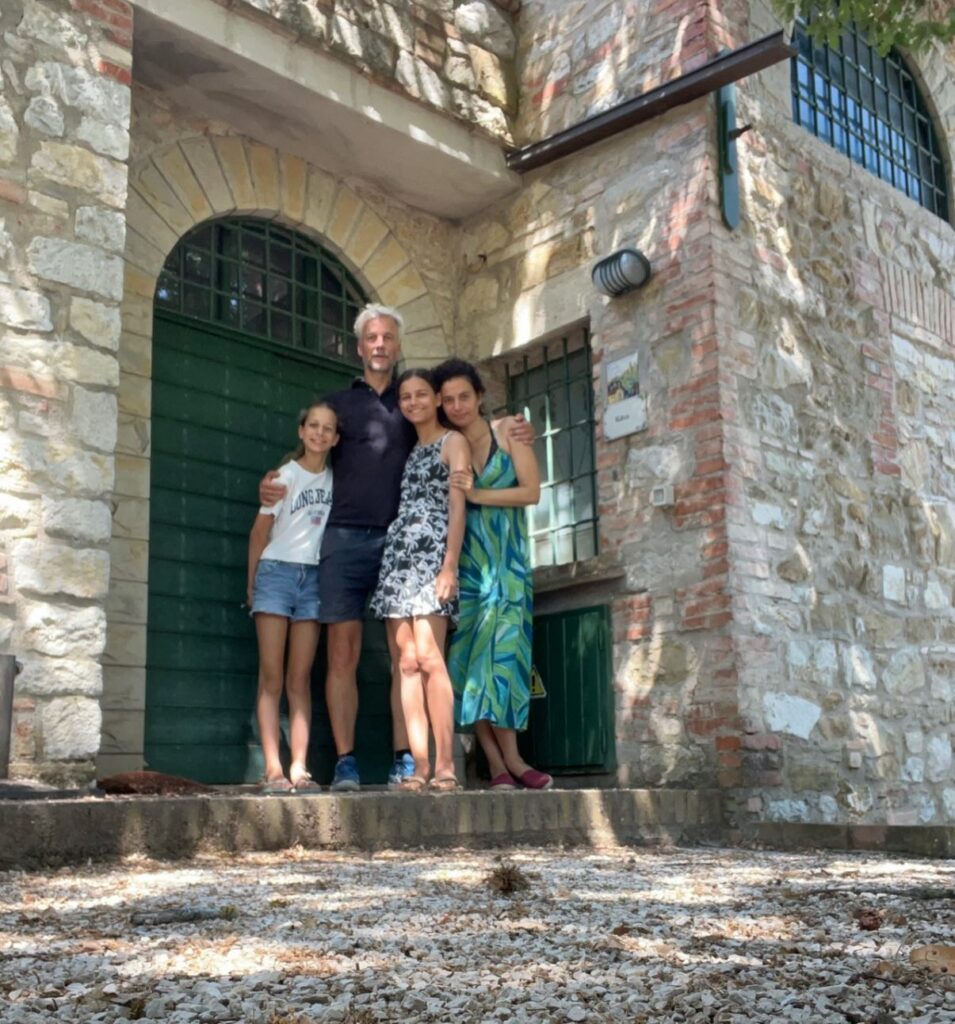 The family in front of the green door of one of the stone buildings
