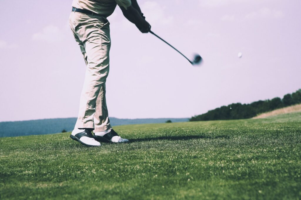 Golfer hits off on a rolling golf course
