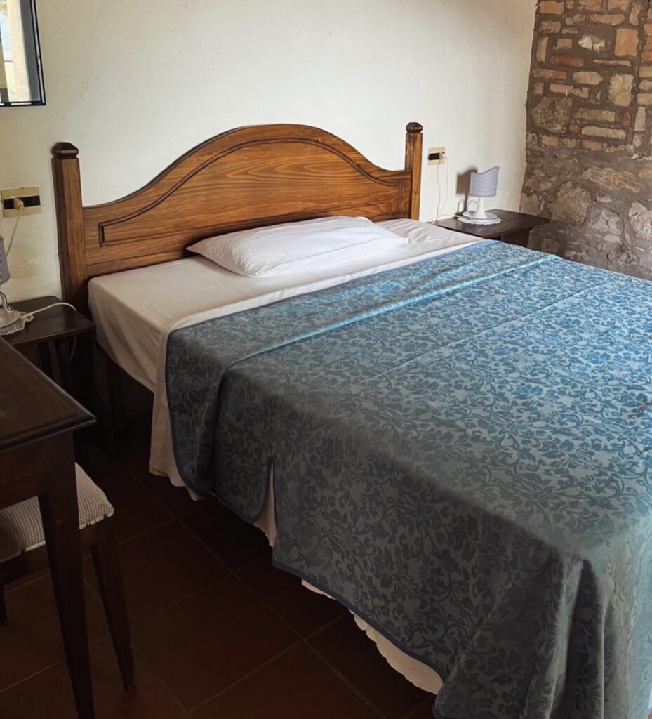 Opgemaakt bed met blauwe sprei in een van de appartementen
