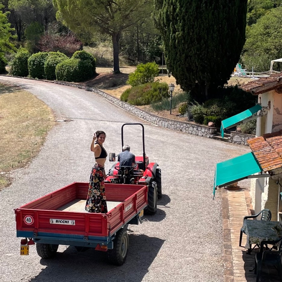 Riding in the trailer behind the red tractor on the driveway