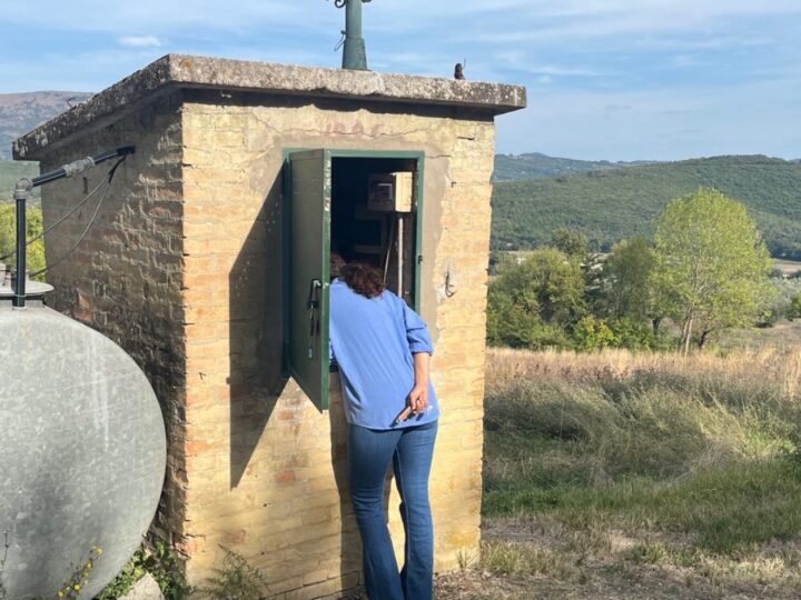 Inside the stone pump house of the well, with the hills of Umbria in the background